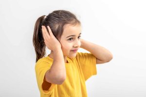 Child holding ear due to earache pain